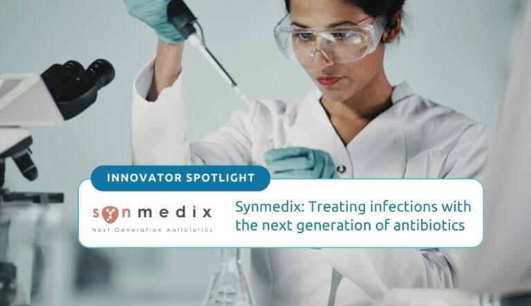 Synmedix: Treating infections with the next generation of antibiotics. Photo of a medical researcher, who is wearing lab PPE, adding a liquid to a test tube via a dropper.